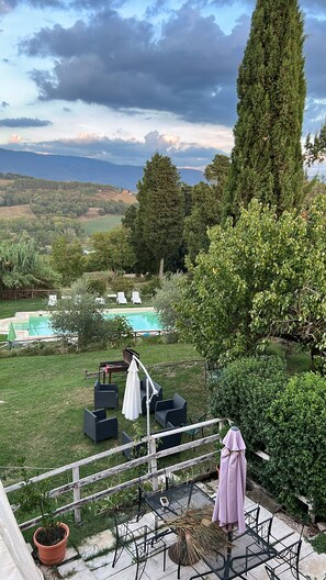 Ein Poolbereich mit Liegestühlen, einem Tisch und Blick auf die Landschaft.