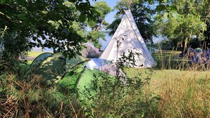 A campsite with a white tent and a green tent.