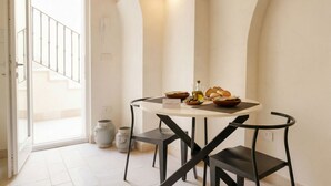 Un comedor con una mesa redonda, sillas negras y vistas a una escalera.