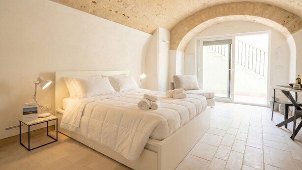 Un dormitorio con una cama grande, un escritorio y una silla.