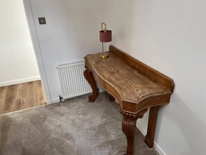 A corner room with a wooden table, a radiator, and a lamp. - Costal Cottage -boddam-sleeps6- Pet Friendly (Peterhead)
