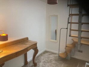 A room with a wooden bench, a lamp, a mirror, and a metal staircase. - Costal Cottage -boddam-sleeps6- Pet Friendly (Peterhead)