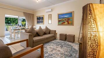 Deluxe Apartment, Balcony, Pool View | Living area | TV