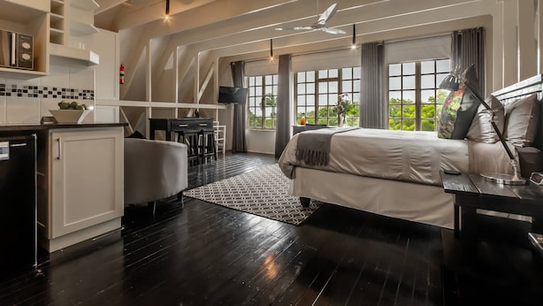 Une chambre d’hôtel moderne équipée d’un grand lit, d’un bureau et d’une kitchenette.