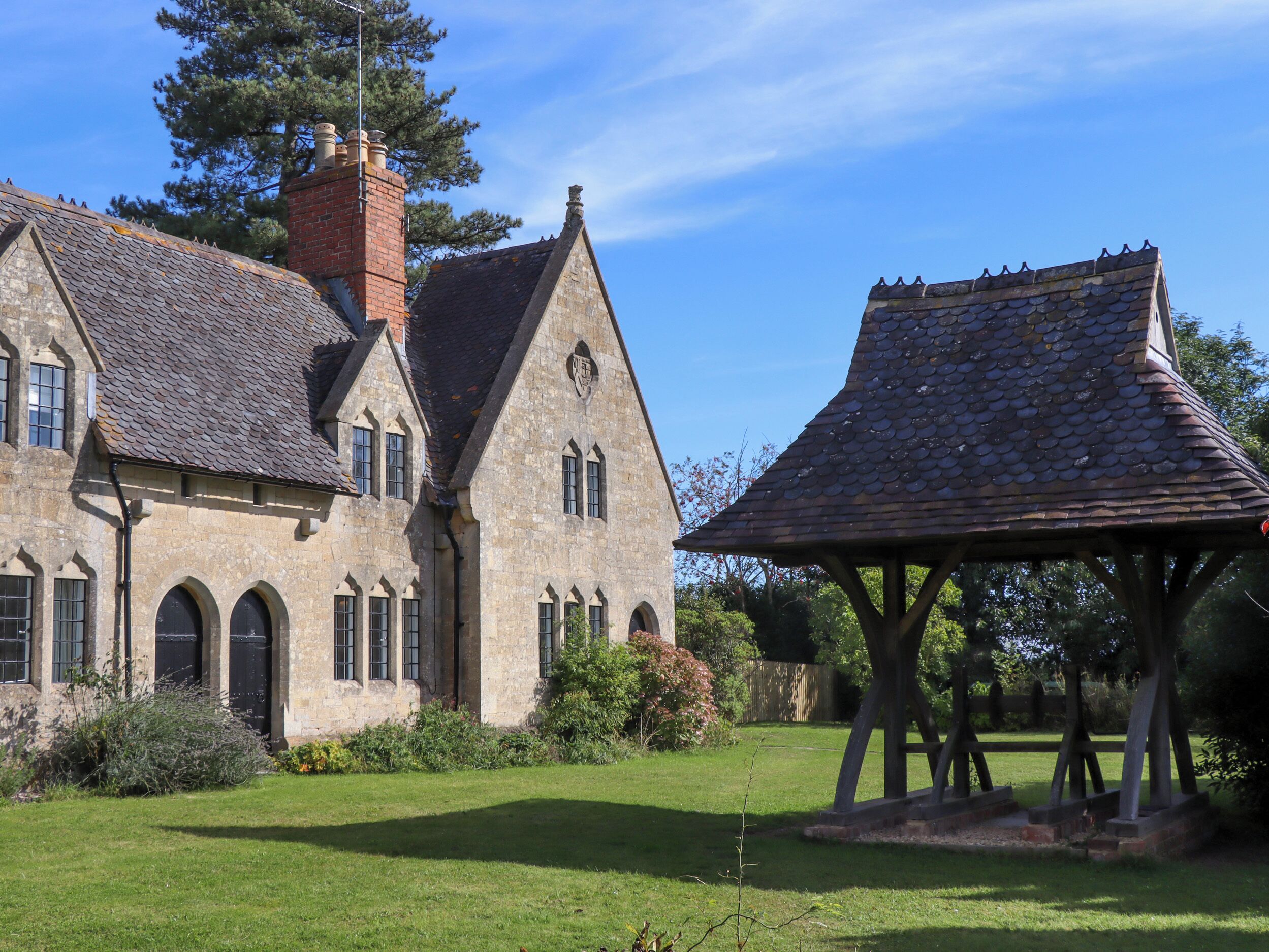 A stone building with a tiled roof and a wooden pavilion.