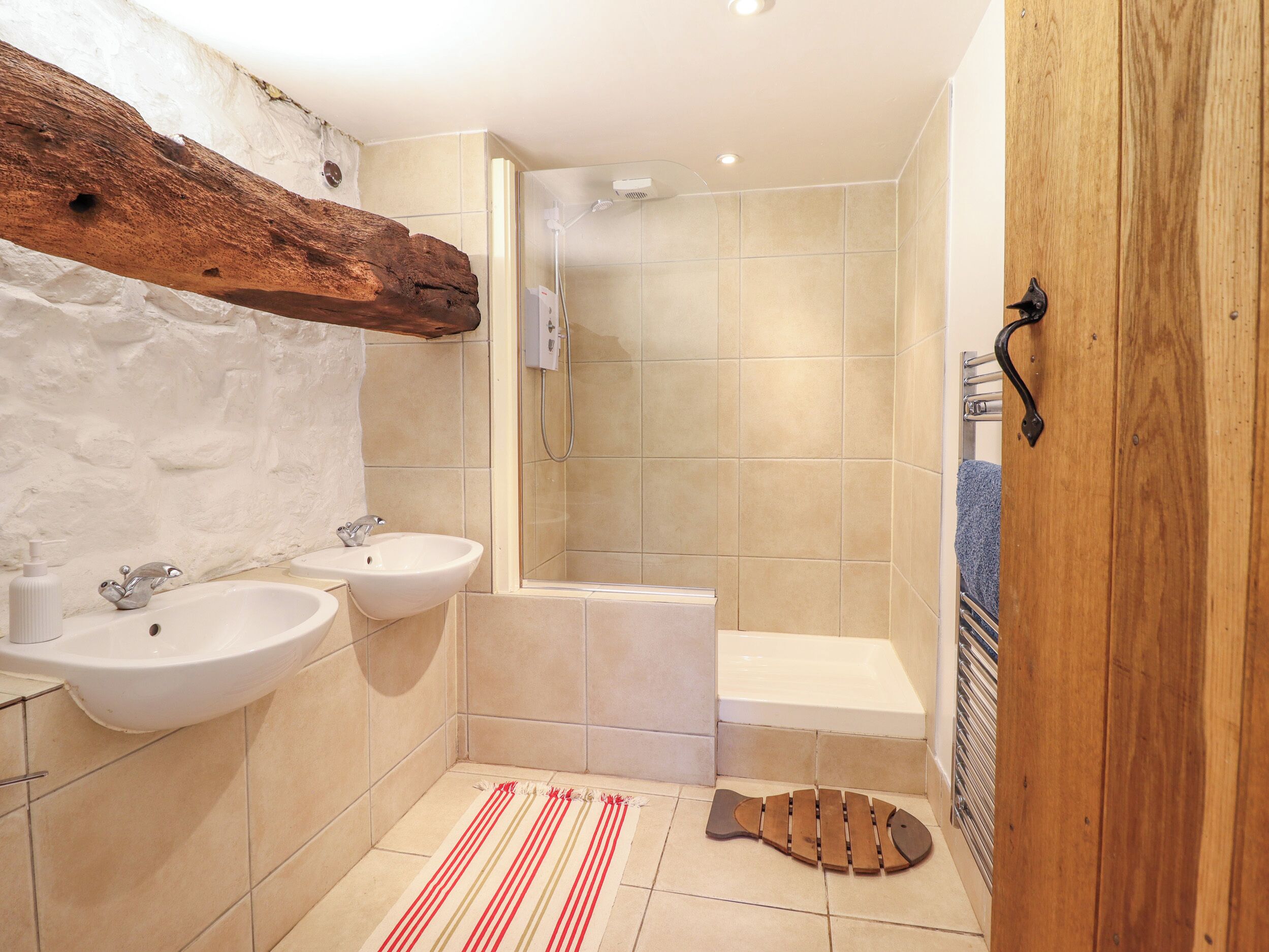 A bathroom with two sinks, a shower, and a bathtub.