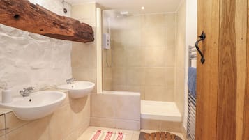 A bathroom with two sinks, a shower, and a bathtub.