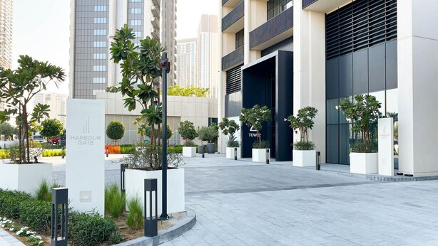 A modern building with a large entrance, surrounded by well-maintained landscaping and a paved walkway.