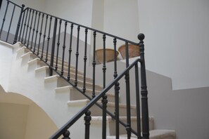 Un escalier avec des balustrades noires et des marches de couleur beige.