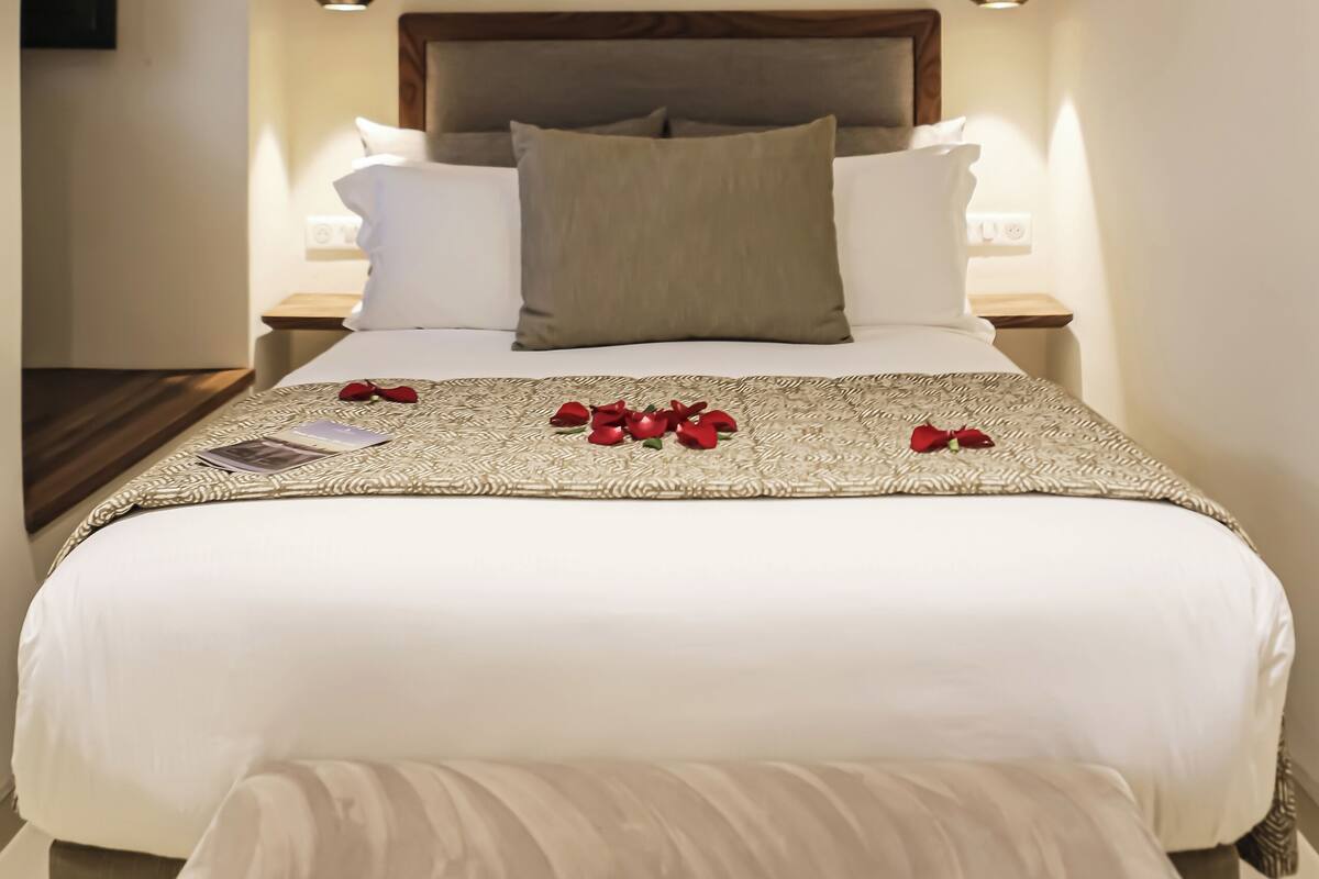A neatly made bed with a white comforter and a decorative pillow arrangement.