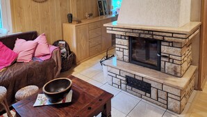 A cozy living room with a stone fireplace, wooden furniture, and a comfortable seating area.