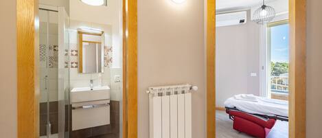 A modern bathroom with a glass shower enclosure, a white sink, and a mirror.