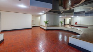 A spacious lobby with a curved reception desk, potted plants, and a large mirror reflecting the space. - Sun & Sea Homes by Wonderful Italy (Sanremo)