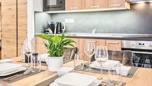 Una cocina moderna con armarios de madera, microondas y horno de acero inoxidable.