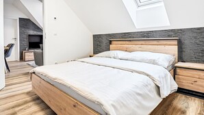 Un dormitorio moderno con tragaluz, estructura de cama de madera y pared gris con textura.