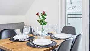 A dining table set with plates, glasses, and a vase with flowers.