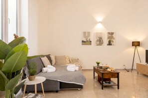 A modern living room with a sofa, a coffee table, and artwork on the wall. - Piazza del Mare - Spacious & Bright Stay near Bari’s Waterfront (Bari)