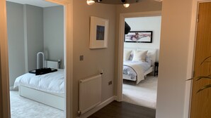 Una camera da letto con un letto bianco, un termosifone e un quadro appeso al muro.
