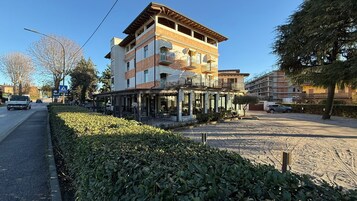 Un edificio de varios pisos con un restaurante en la planta baja y balcones en los pisos superiores.
