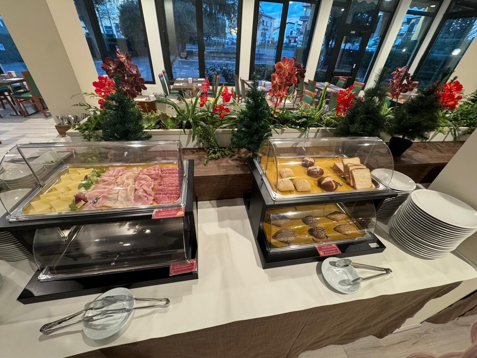 Een buffet met diverse gerechten en uitzicht op het exterieur door grote ramen.