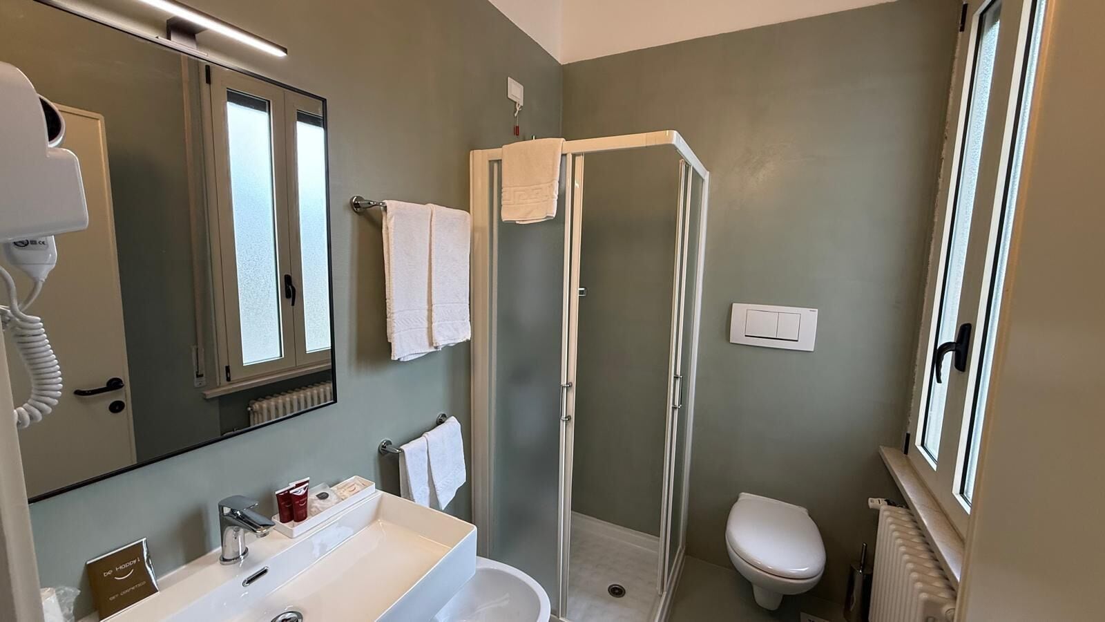 A bathroom with a shower, toilet, and sink.