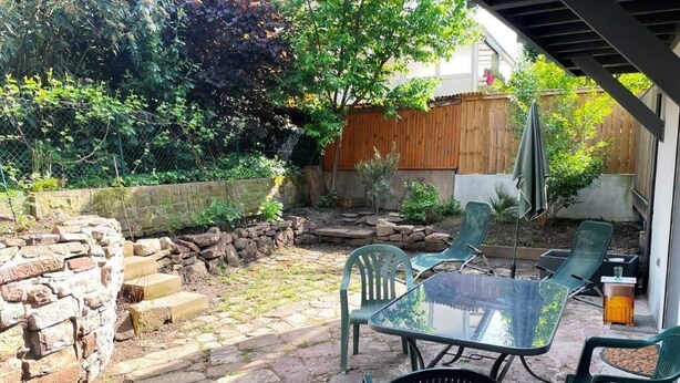A patio area with a stone pathway, a glass table, and green chairs. - Nice flat in villa, quiet 10mn from the center, streetcar 100m, free parking. (strasbourg)