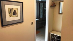 A hallway with a framed artwork, a coat rack, and a glimpse of a bathroom with a mirror and towel rack. - Nice flat in villa, quiet 10mn from the center, streetcar 100m, free parking. (strasbourg)