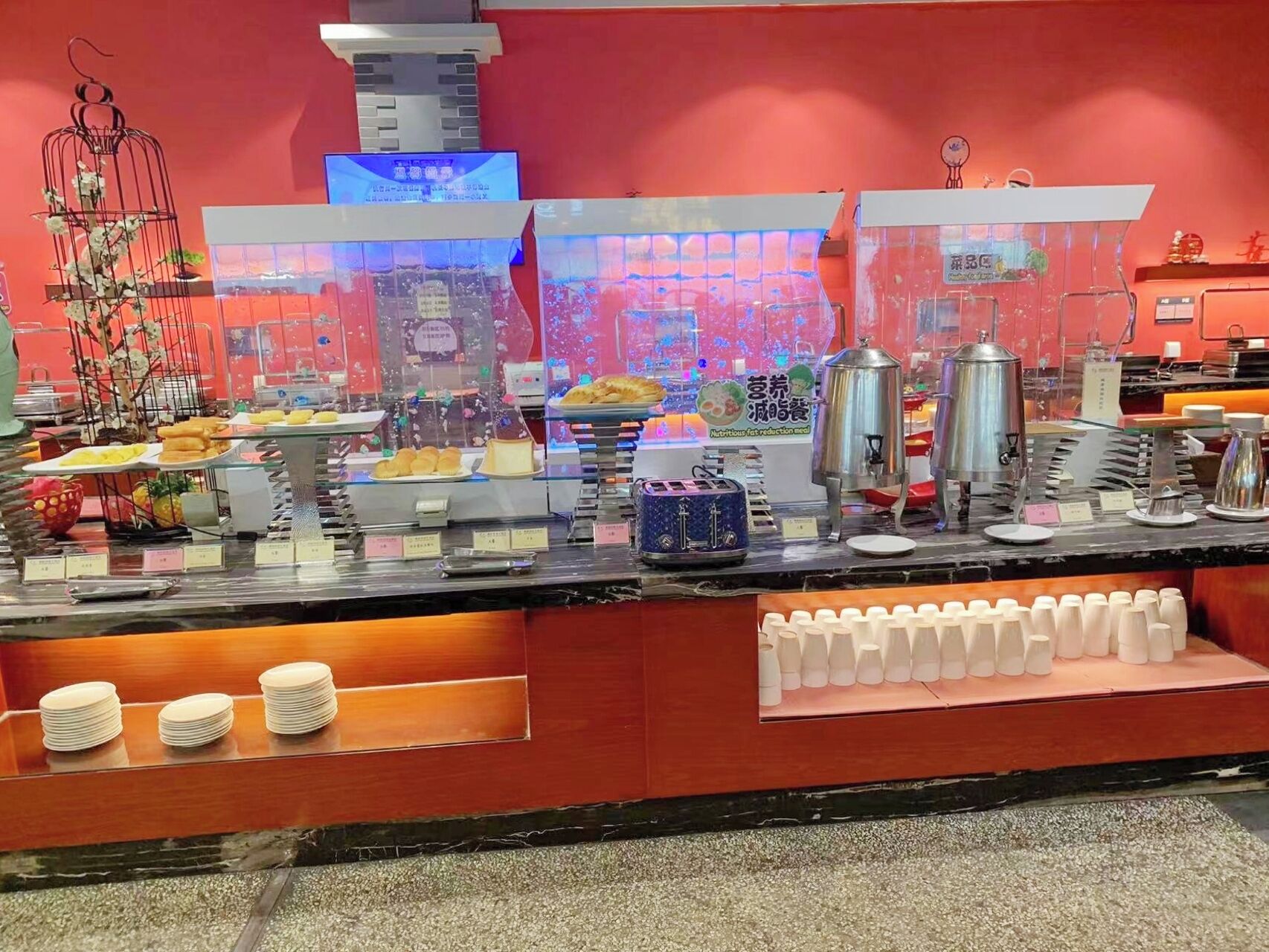 Un comptoir de buffet proposant divers plats, une machine à café et une plante décorative.