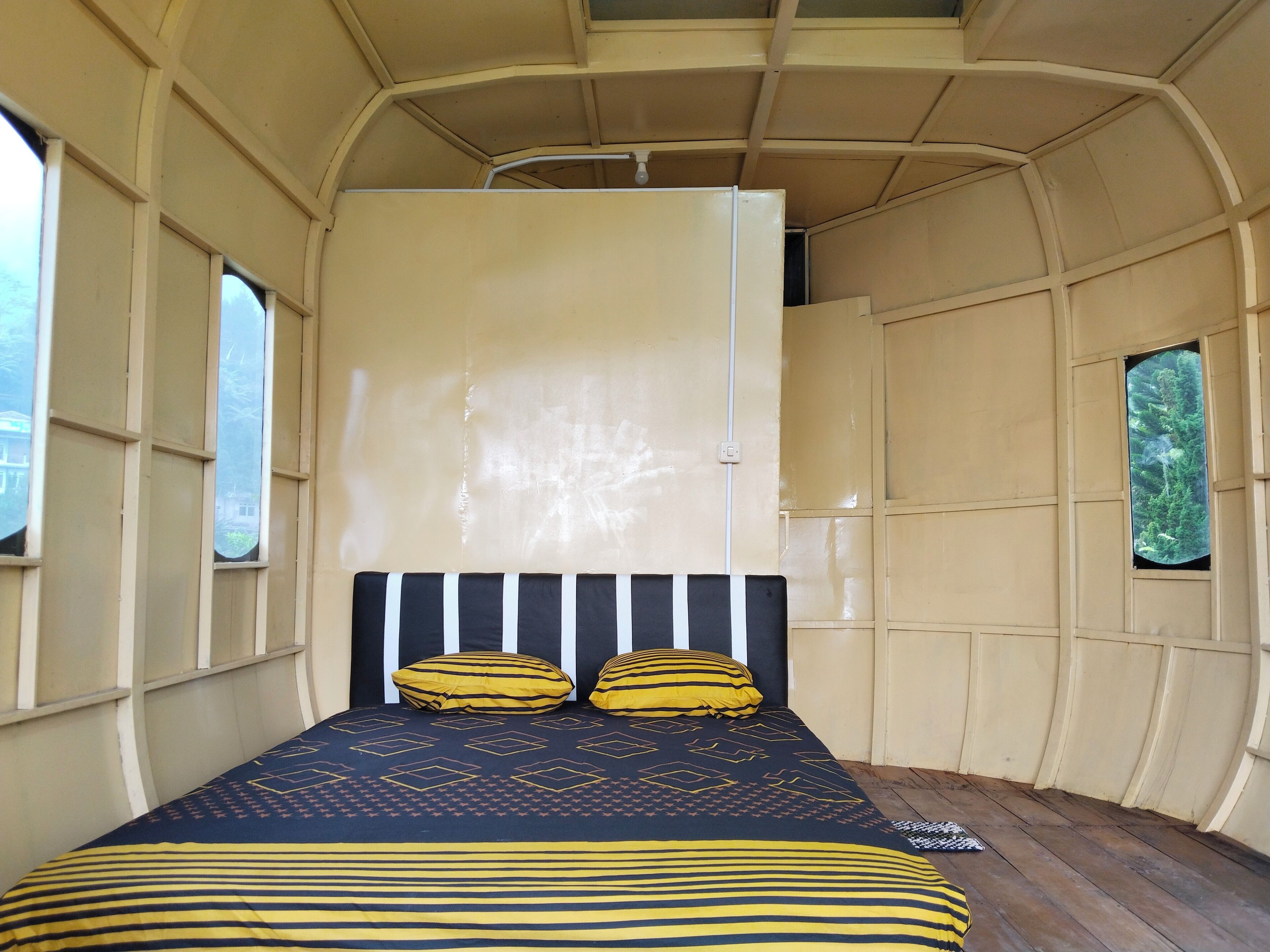Una habitación con una cama, una ventana y una puerta.