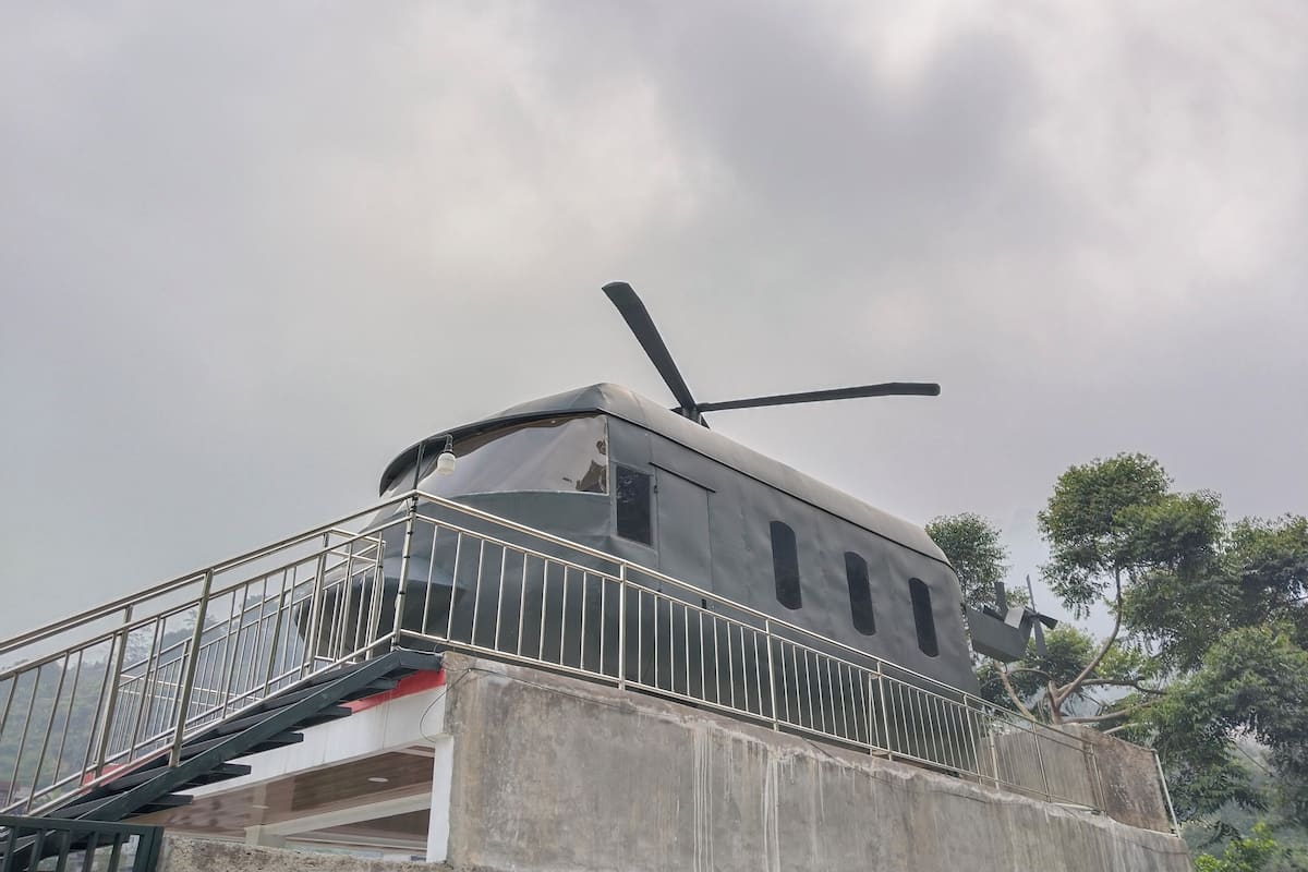 A building with a helipad on the roof, a staircase leading to an upper level, and a metal railing.