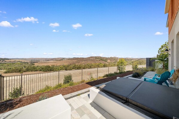 A balcony with a view of a hilly landscape, a metal fence, and a few chairs. - @ Marbella Lane - Curated 5BR in Upscale RMV Haven (San Juan Capistrano)