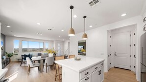 A modern kitchen with a central island, white cabinetry, and pendant lighting. - @ Marbella Lane - Curated 5BR in Upscale RMV Haven (San Juan Capistrano)