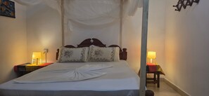 A neatly made bed with a white duvet, two bedside lamps, and a canopy overhead. - Furaha Beach Bungalows by Serenity (Jambiani)