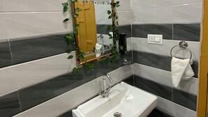 Un baño con un lavamanos blanco, un espejo con marco de madera y un perchero para toallas.