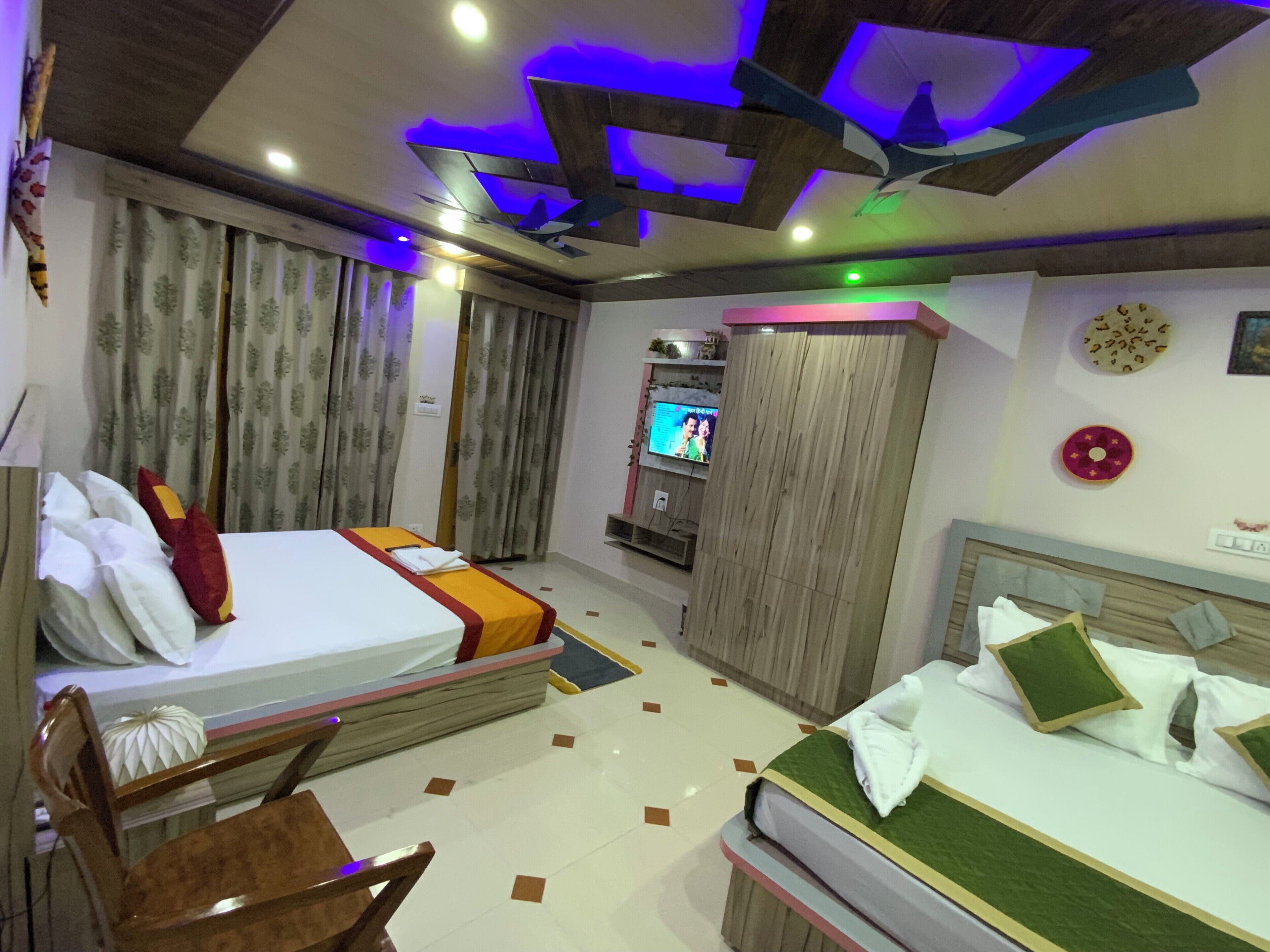 A hotel room with a bed, a desk, a TV, and a wardrobe.