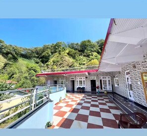 Un hôtel avec un sol à carreaux, un balcon et une vue sur une colline verdoyante.