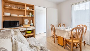 A compact living space with a kitchenette, dining area, and a bed.