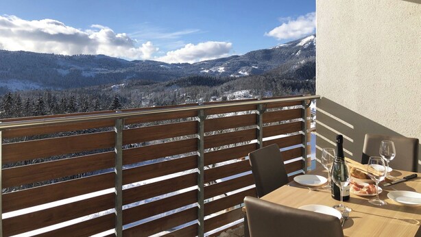 A dining area with a table set for two, overlooking a mountainous landscape. - 104 – 6 PAX TERRACE (LAVARONE)