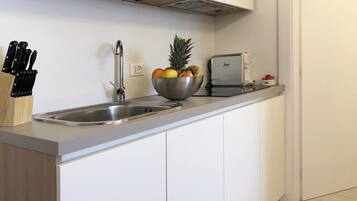 Una cocina moderna con un lavamanos de acero inoxidable, un frutero y un tostador.