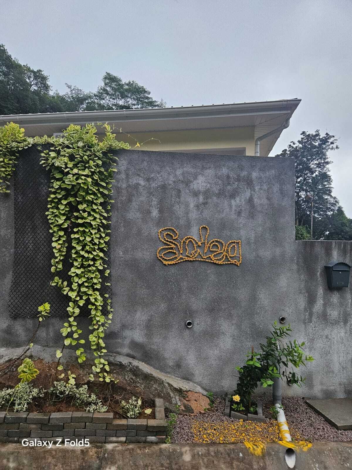 Un edificio con una pared gris y un letrero que dice 'Soleq'.
