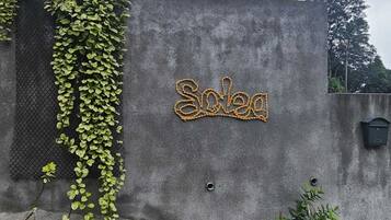 Un edificio con una pared gris y un letrero que dice 'Soleq'.