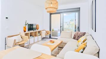A modern living room with a sofa, coffee table, and TV.
