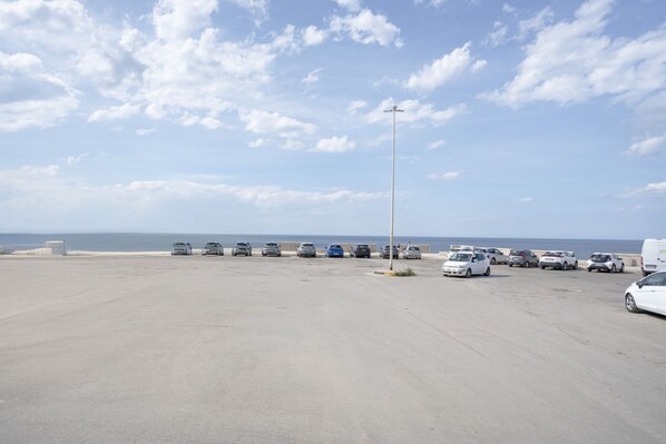 A parking lot with several cars and a street lamp.