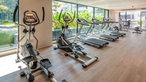 Ein Fitnessraum mit Cardiogeräten und einem großen Fenster.