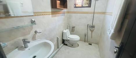 A bathroom with a sink, toilet, and shower.