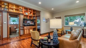 A spacious living room with a wooden entertainment center, a comfortable seating area, and a large window providing natural light. - Rosé  All Day Hideaway (Walla Walla)