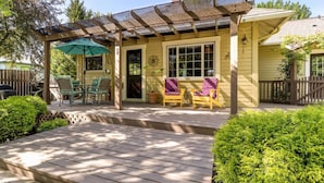A covered porch with two chairs and a table, a wooden deck, and a green umbrella. - Rosé  All Day Hideaway (Walla Walla)