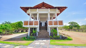 A two-story building with a red roof and white walls, featuring a central staircase and wooden balconies. - Tranquil 3-bedroom villa in elewankuluma Puttalam , near wilpattu safari park (puttalam)