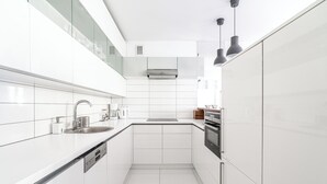 Een moderne keuken met witte kasten, een roestvrijstalen spoelbak en een ingebouwde oven.