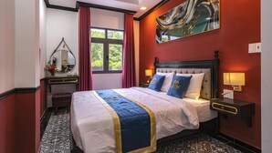 A hotel room with a large bed, a nightstand, a mirror, and a window with curtains. - Dancentre Airport Stays - Vyvy Hotel (Ho Chi Minh City)